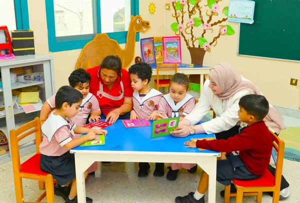 Teacher guiding children during a classroom learning activity