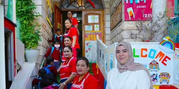 Children and teachers welcoming families at the nursery entrance